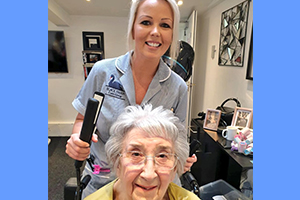 care home manager Danielle doing resident's Hazel's hair