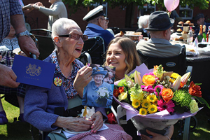 Hilda Fleming reads her card from the Queen on her 100th birthday with Aaron Court Care Home activities coordinator Amy Jones