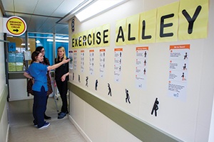 Nurses pointing to wall graphics to promote strength and balance