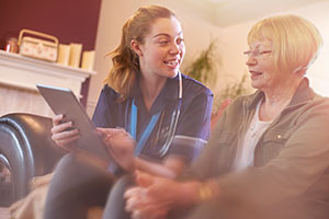 Care home nurse urging resident to embrace technology