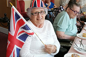 elderly woman attending indoor street party