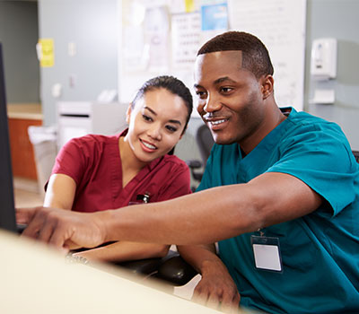 social care workers look at a computer screen