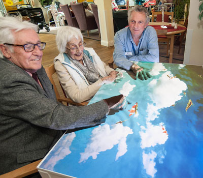 Residents sat around a light projection table