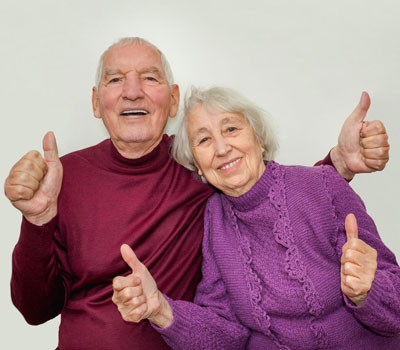 Old couple from Robinson House Care Home giving the thumbs up sign