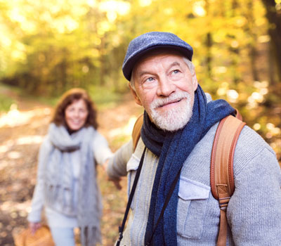 Two seniors on a walk in forest