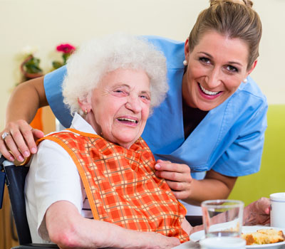 Resident that needs dementia care eating food with carer