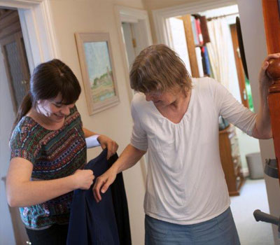 Care home staff helping older people put on their coats so they can go outside and vote