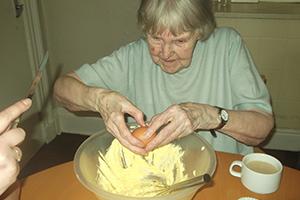 Woman cracking an egg on Carrot Cake Day 