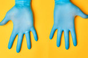 infection control - hands in plastic gloves