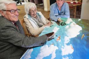 Residents sat around a light projection table