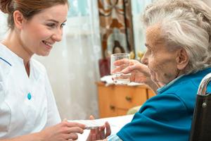 healthcare – a nurse helps an elderly resident with her medication