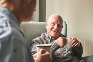 Male resident having a cup of tea with NHS workers