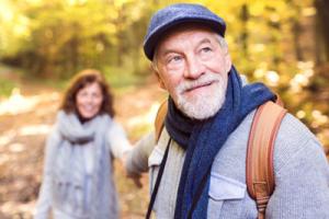 Two seniors on a walk in forest