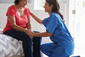 Care home bedroom with elderly lady and care worker - What makes a safe home for the elderly?